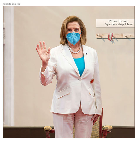 Nancy Pelosi, wearing a face mask, stands in front of a peg rack that has a pair of dentures hanging from it beneath a sign that reads Please Leave Speakership Here, and waves goodbye as she steps down